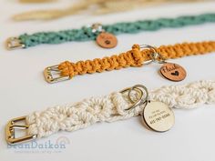 there are three different types of bracelets on the white table and one has a name tag attached to it