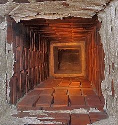 the inside of a brick tunnel with light coming in from it's center hole