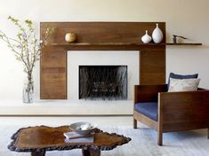 a living room with a fire place and some vases on the table in front of it