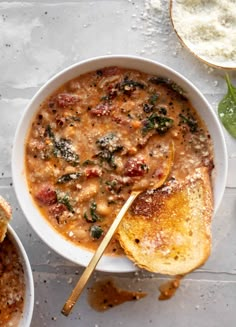 two bowls of soup with bread on the side