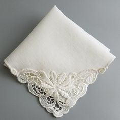 an embroidered white handkerchief on a gray background