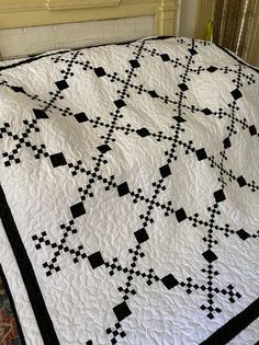 a black and white quilt sitting on top of a bed