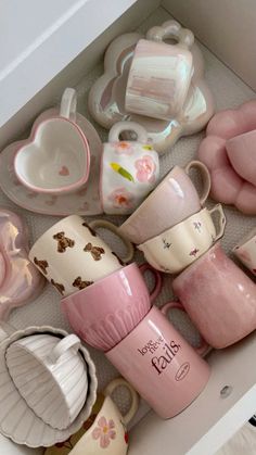 a drawer filled with lots of pink and white cups