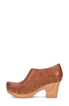 A half d'Orsay upper adds unique style to this 60s inspired clog. 2.5" heel, 1" platform Round toe Stud details Slip-on Wood heel Manmade upper and sole Imported Retro Platform Clogs With Round Toe, Retro Style Platform Clogs With Round Toe, Modern Clogs With Wooden Wedge Heel, Chic Clogs With Platform And Almond Toe, Chic Platform Clogs With Almond Toe, Chic Almond Toe Platform Clogs, Brown High Heel Clogs With Sculpted Heel, Brown Clogs With Sculpted Heel For Spring, Retro Mules With Wooden Heel And Round Toe