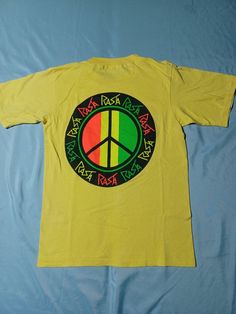 Super cool original Rasta Peace tee from late 80s, early 90s. EXACT MEASUREMENTS IN LISTING AND PHOTOS. Freshly washed and ready to wear! Such a sweet design. Amazing design and rare piece of Rasta history. Very unique neon print. Oneita Single Stitch Made in USA Tag from 80s and 90s. Tagged S, fits S or XS. 17 X 23.5 Minor wear spot in last pic. See pics for size and details! Vintage 1980s 80s 1990s 90s Rasta Rastafarian Peace Sign Neon Surf Surfer Surfing Hawaii Hawaiian Beach Ocean Wave Stree Surfing Hawaii, Surf T Shirts, Neon Printing, Hawaii Surf, Surf Tshirt, Hawaiian Beaches, Ocean Wave, Peace Sign, Super Cool