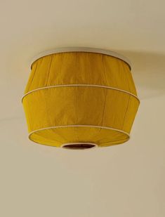 a yellow lamp shade hanging from the ceiling