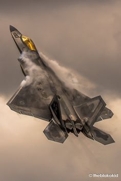 a fighter jet is flying through the cloudy sky