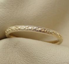 a wedding ring with filigrees on the inside is sitting on a white cloth