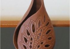 a brown vase sitting on top of a wooden table