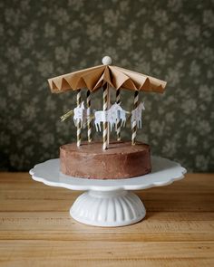 a chocolate cake topped with umbrellas on top of a wooden table