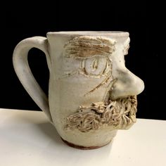 a ceramic cup with a face on it