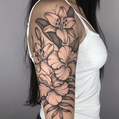 a woman's arm with flowers and leaves on the back of her shoulder, in black and white