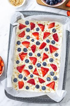 an uncooked cake with strawberries and blueberries on it