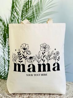 a tote bag with the word mama printed on it and flowers in black ink