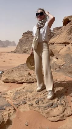 a woman standing on rocks in the desert