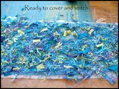 a pile of blue and yellow yarn sitting on top of a wooden table next to a ruler