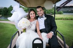 a bride and groom sitting in a golf cart