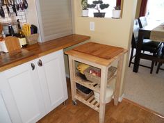 a kitchen with a wooden counter top and white cabinets