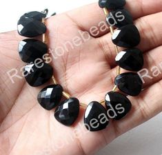 a hand is holding some black beads