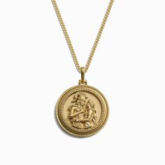 a gold necklace with an image of a man holding a woman's head on it