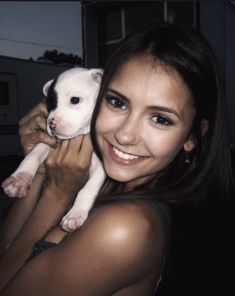 a woman holding a small dog in her arms