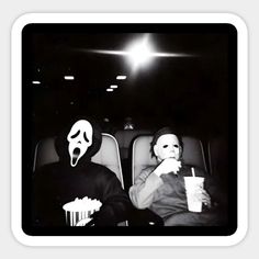 two people sitting in the back of a car with masks on their faces and one holding a drink