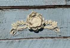 a decorative flower on the side of an old wooden door