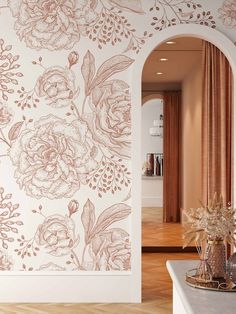 an archway leading into a living room with flowers on the wall and wooden flooring