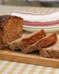 sliced meatloaf sitting on top of a wooden cutting board