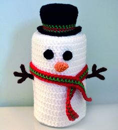 a crocheted snowman is wearing a hat and scarf