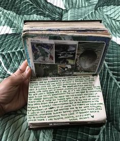 an open book with pictures and words on it in someone's hand over a bed