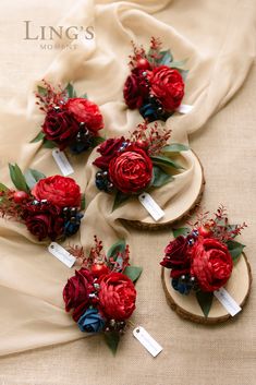 red flowers and greenery are arranged on wood slices for the bride's boutions