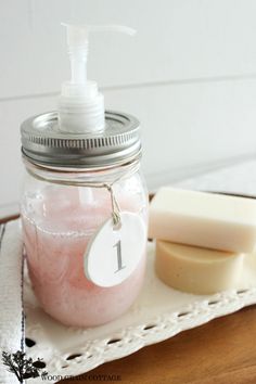 a mason jar with soap and lotion sitting on a tray