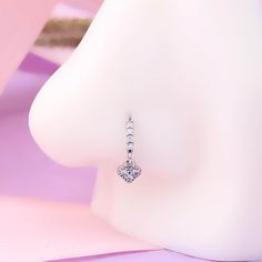 a pair of heart shaped earrings sitting on top of a mannequin's head