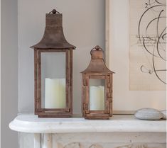 two wooden lanterns sitting on top of a mantle