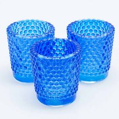 three blue glass cups sitting next to each other