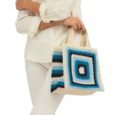 Crafted from durable canvas, this tote is sure to become an everyday essential. But what truly sets it apart is the exquisite cotton crochet design in shades of serene blue and pristine white that gracefully adorns its surface. The delicate interplay of hues weaves a story of elegance and simplicity, reminiscent of sun-kissed beaches and crisp ocean waves. All Sales Final. White Square Crochet Bag For Shopping, White Crochet Tote Bag, White Crochet Tote Bag For Everyday, White Square Cotton Canvas Bag, Handmade Cotton Crochet Bag, Eco-friendly Cream Crochet Cotton Bag, Everyday Blue Woven Shoulder Bag, Eco-friendly Cream Cotton Crochet Bag, Daily Use Cotton Crochet Bag