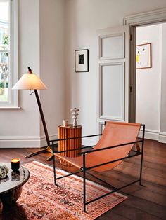 a living room with a chair, lamp and rug