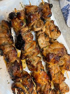 chicken skewers on a plate with lemon wedges