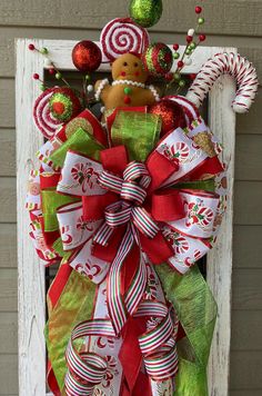 a christmas wreath with candy canes and a gingerbread man on the front door