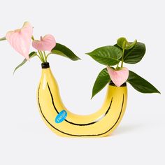 a banana shaped vase with pink flowers in it