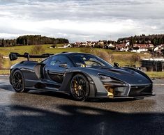 a black and yellow sports car parked on the side of the road in front of some houses