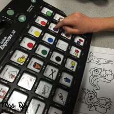 a person using a large black and white calculator on a table with coloring pages