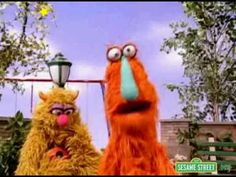 two sesame street characters standing next to each other