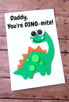 a father's day card with a green and orange dinosaur on it, says daddy you're dino - mite