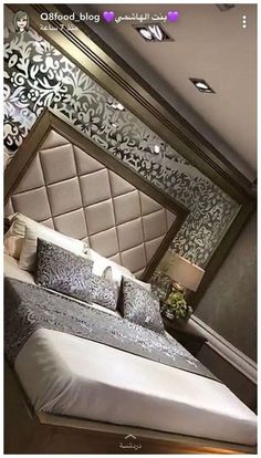 a bed sitting in the middle of a bedroom next to a wallpapered headboard