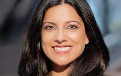 a woman with long black hair smiling at the camera