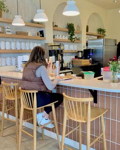 a woman sitting at a counter in a coffee shop