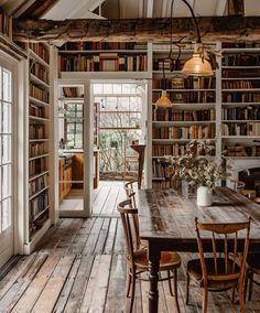 a table and chairs in a room with bookshelves