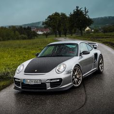 a silver porsche parked on the side of a road